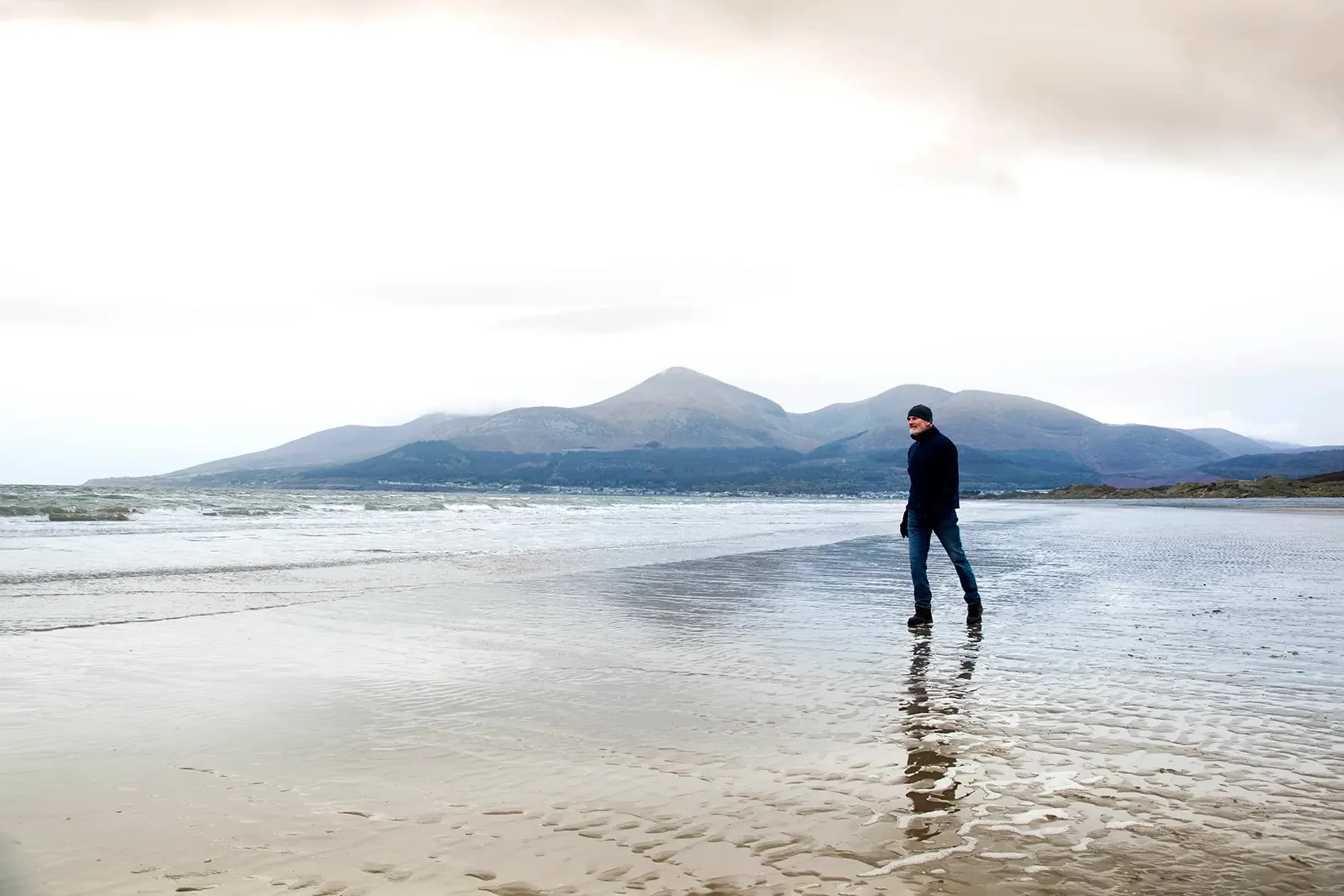 Elderly man walking on beach
