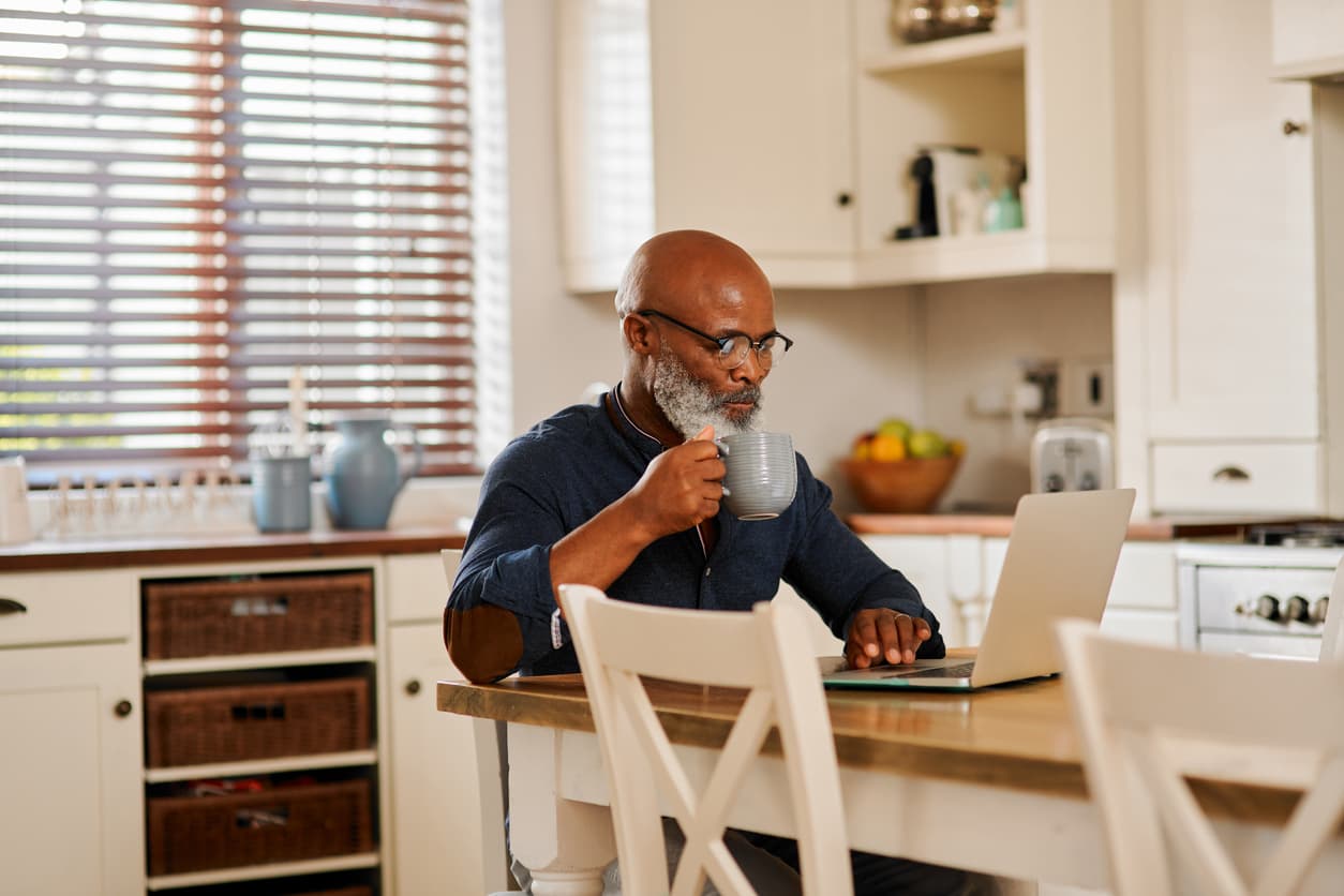 Man on his laptop drinking a hot beverage